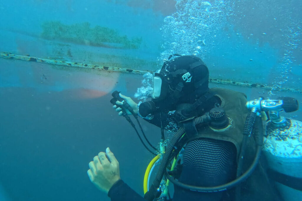 Diver inspecting a vessel hull at Suape anchorage, Brazil